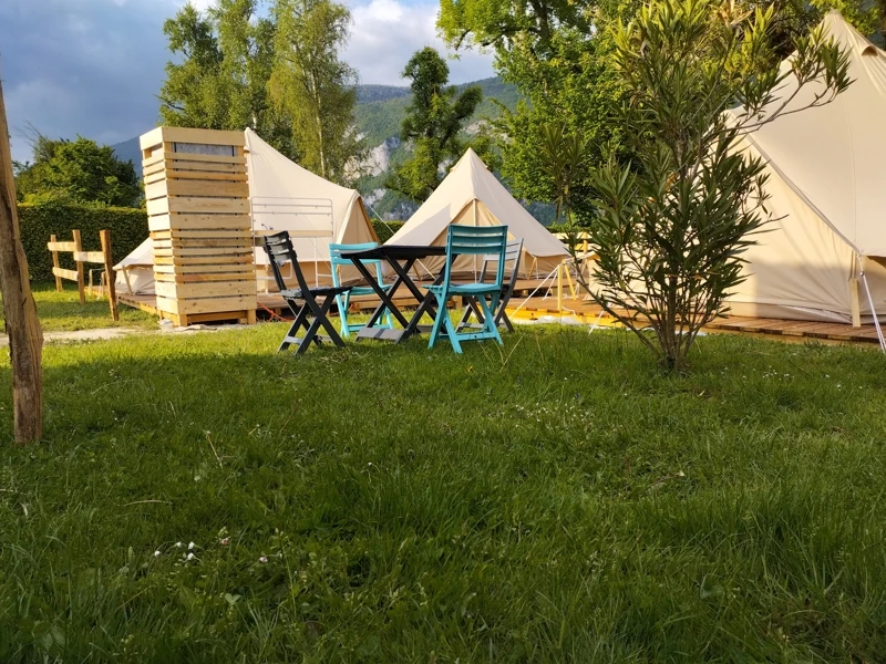Camping avec trois tentes lodges premium et un petit salon de jardin
