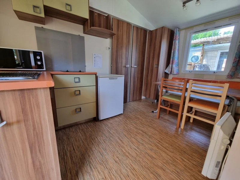Espace à vivre en mobil-home avec cuisine et coin repas