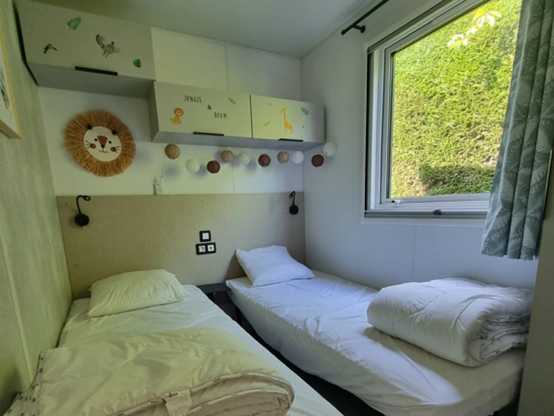 Chambre décorée pour enfants avec deux lits dans un mobil-home