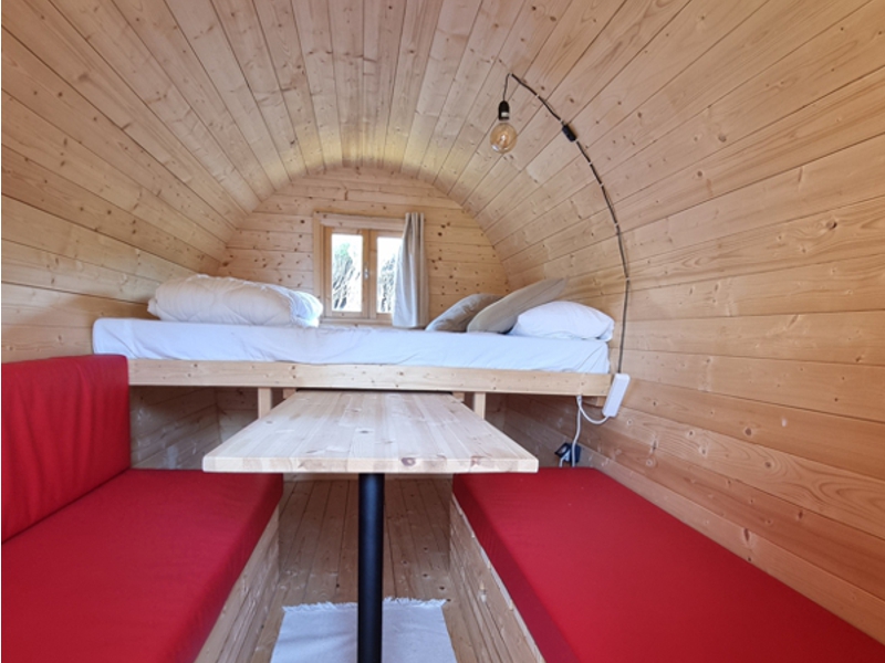 Agencement de l'espace intérieur d'une roulotte avec couchage, table et banquettes