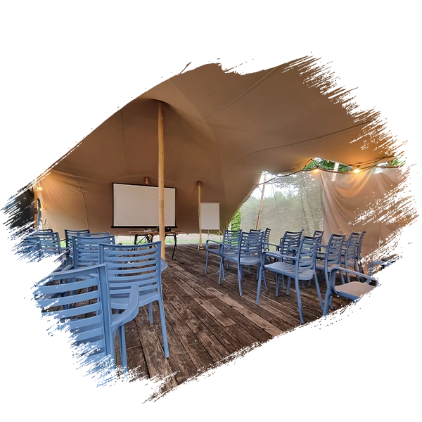 Salle de réunion sous une tente avec écran, paper board et chaises